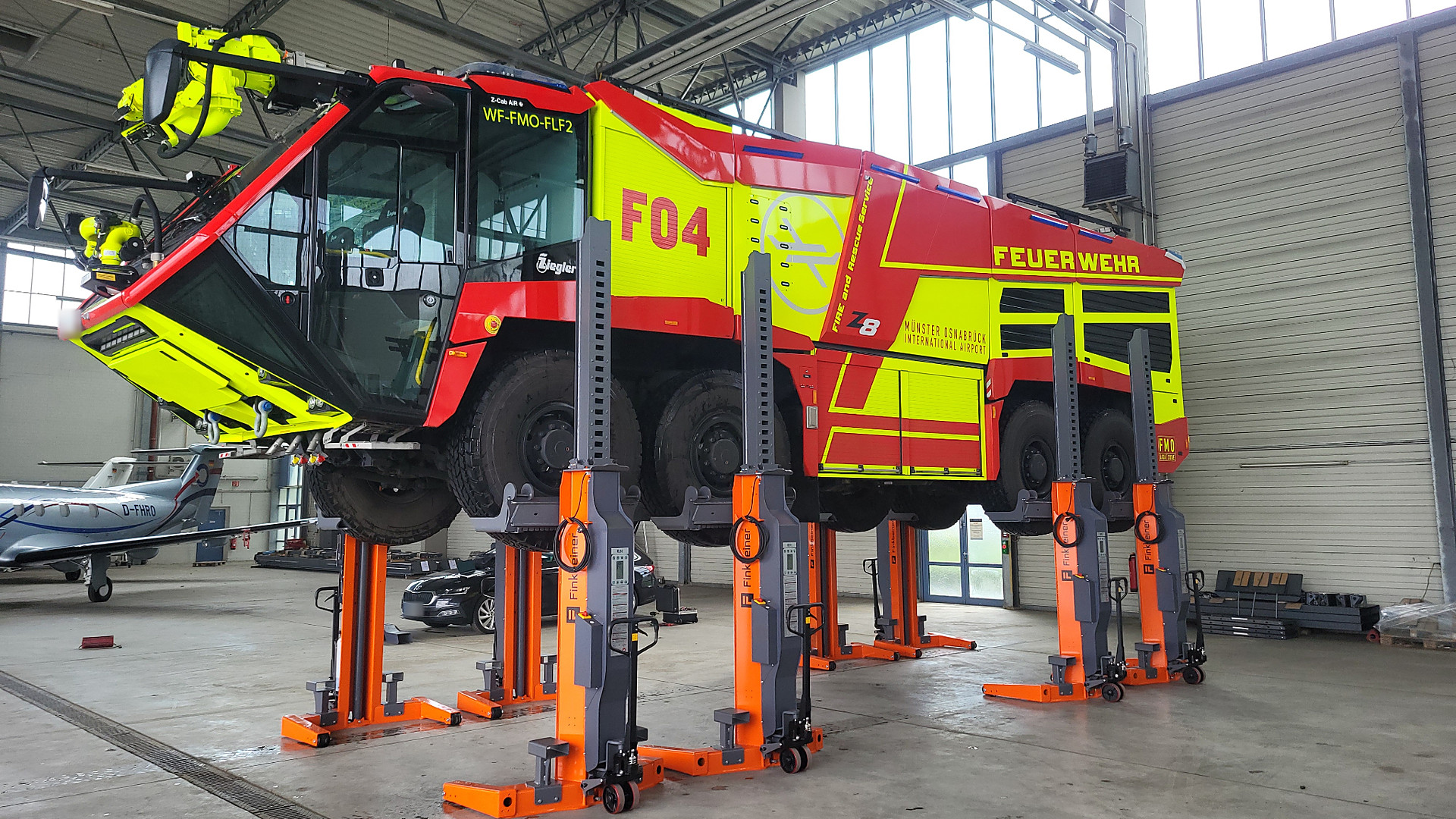 Finkbeiner wireless mobile column hoists lifting an airport fire truck