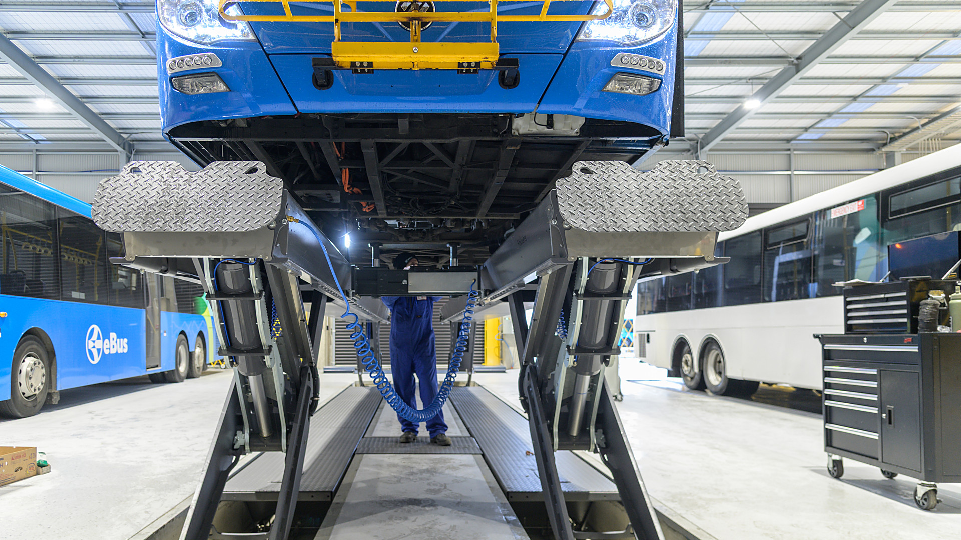 Finkbeiner HDS semi-scissor platform lift in an electric bus workshop